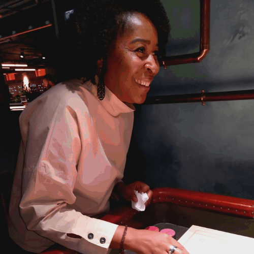Ashden team member, Anita Henderson, smiling and sitting at a table