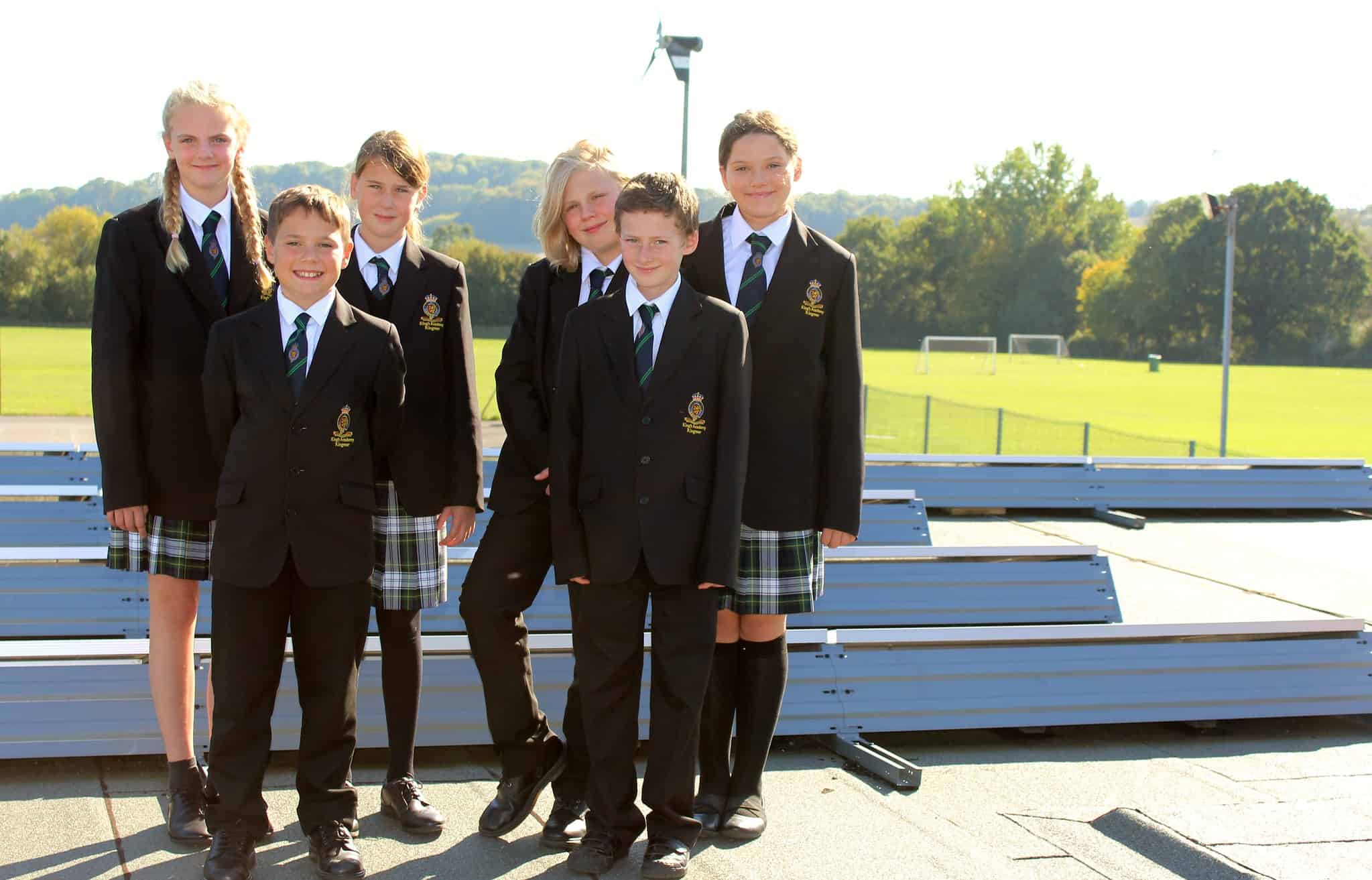 School pupils stand next to solar panels