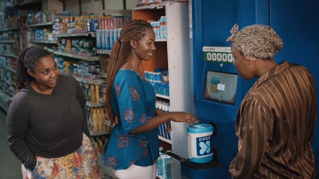 A woman filling a container at an ATM