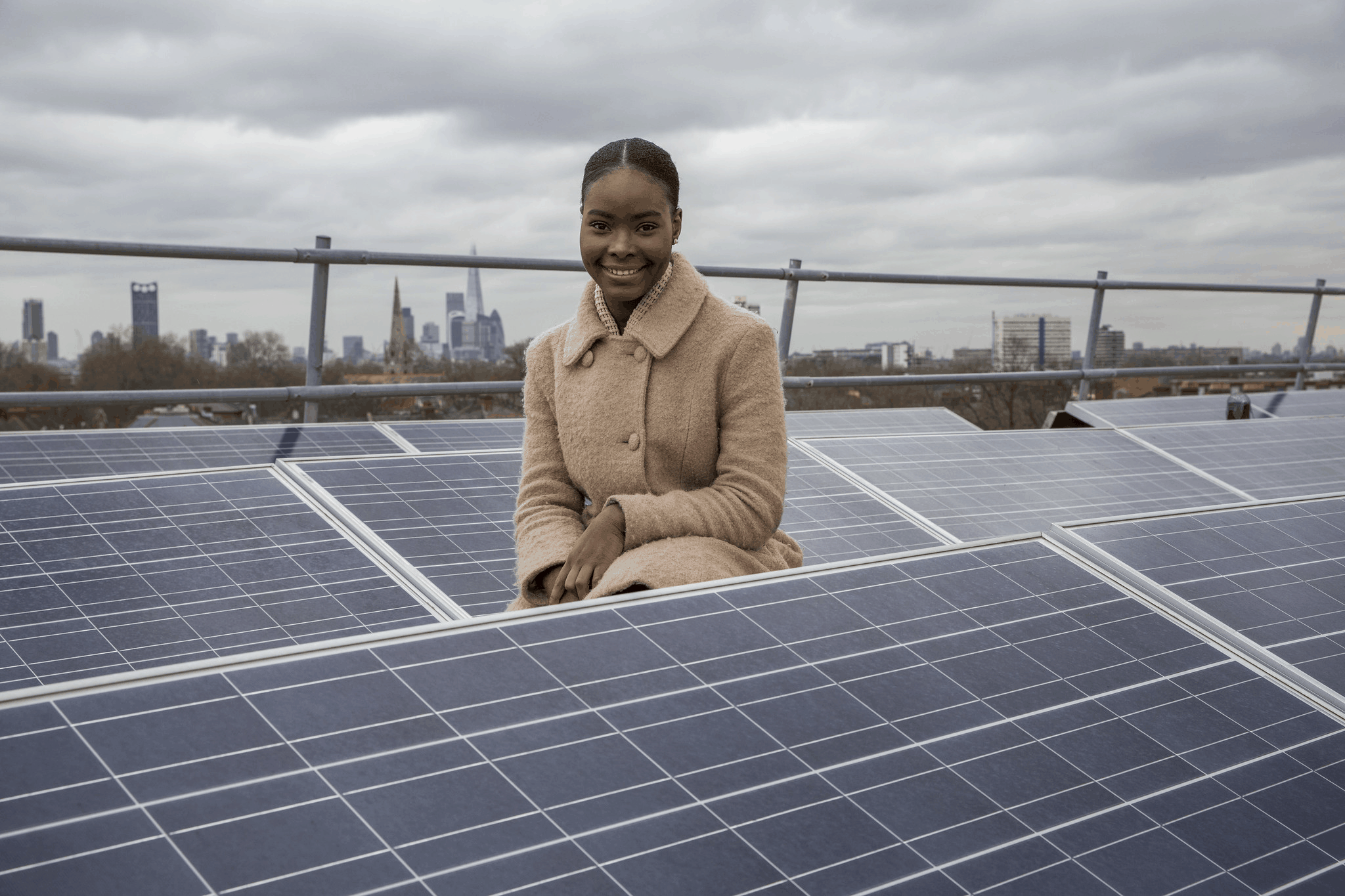 A woman kneeling by some solar panels