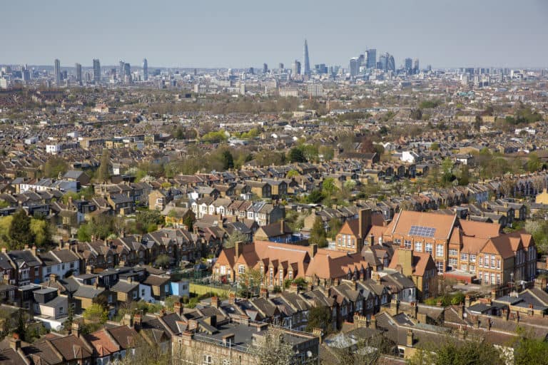 A landscape shot of houses in London, with the city's skyline in the background
