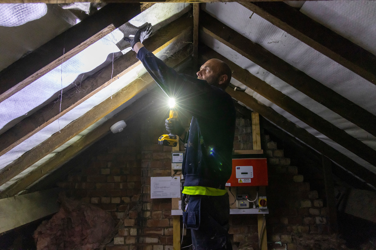 A man putting in loft insulation