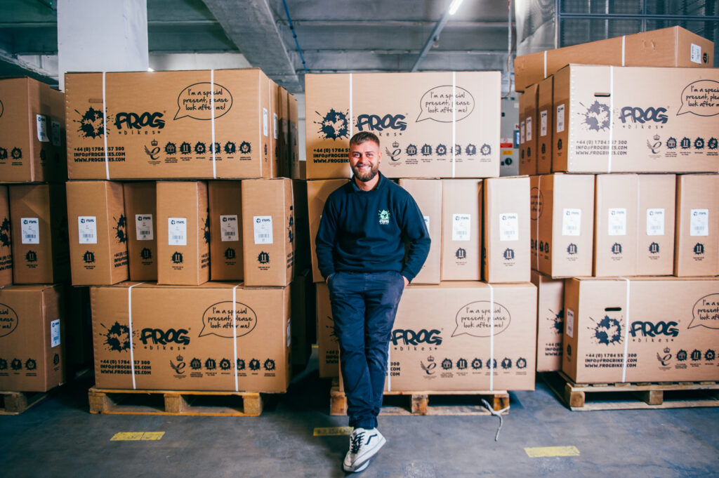 A man standing in front of cardboard boxes