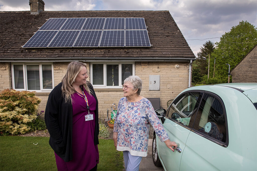 Two females standing outside a house with solar panels on